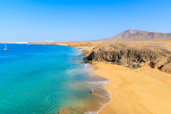 Couple of people in turquoise ocean water on Papagayo beach, Lanzarote, Canary Islands, Spain