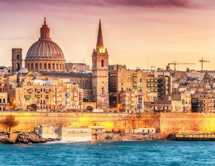 Valletta, Malta: skyline from Marsans Harbour at sunset. The cathedral