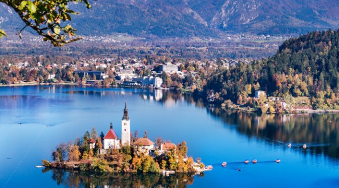 Bled, Slovenia - Panoramic aerial view of Lake Bled with Church of the Assumption of Maria, traditional Pletna boats at autumn background