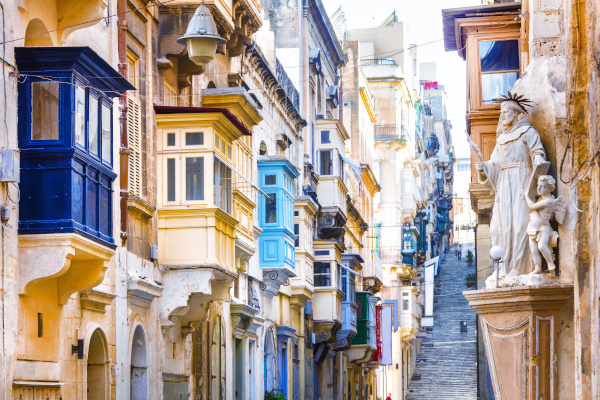 Typical narrow streets with colorful balconies in Valletta , Malta