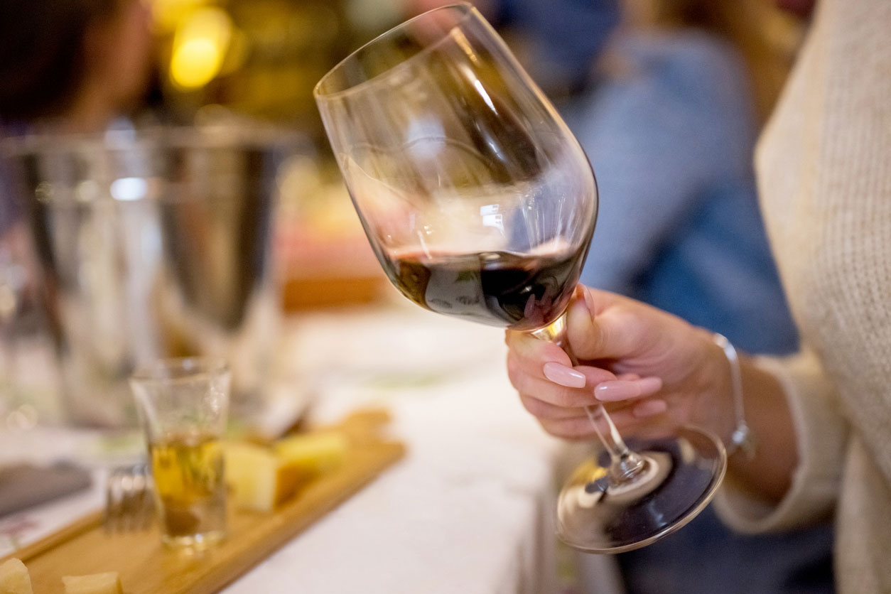 Eine Frau schwenkt ihr Glas Wein.