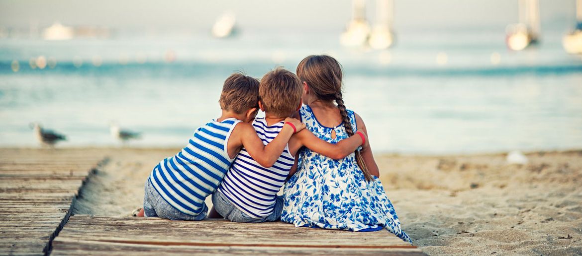 Kinder sitzen am Strand auf Mallorca