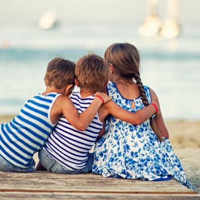 Kinder sitzen am Strand auf Mallorca