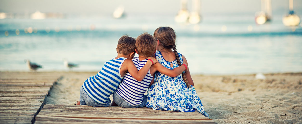 Kinder sitzen am Strand auf Mallorca