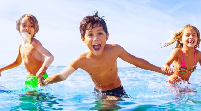 Kinder spielen im Wasser.